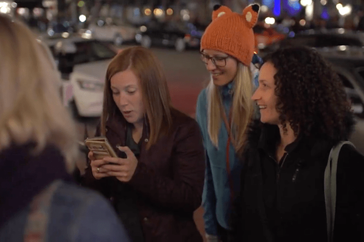 a group of people looking at a cell phone