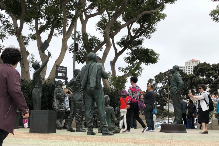 a group of people standing next to a tree